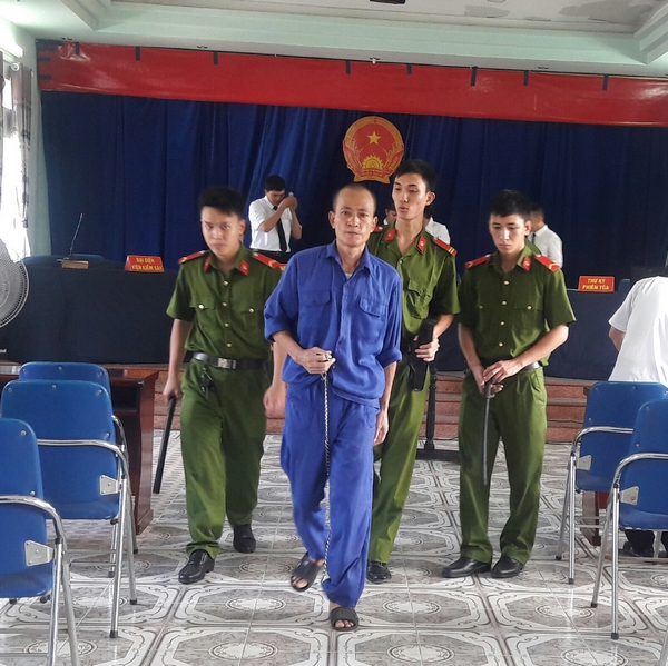 Lực lượng công an dẫn giải bị cáo Đinh Văn Lợi tại phiên tòa. Ảnh NH