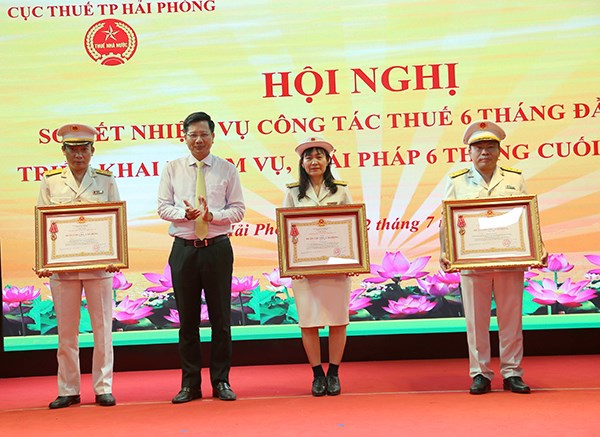 Phó Chủ tịch Thường trực UBND TP Lê Anh Quân trao tặng Huân chương cho 3 cá nhân. 