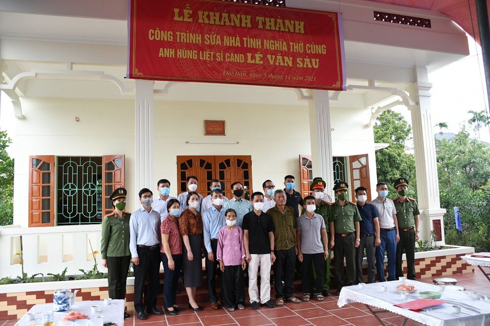 Các đại biểu chụp ảnh cùng thân nhân liệt sỹ Lê Văn Sáu tại ngôi nhà mới hoàn thành sửa chữa.  