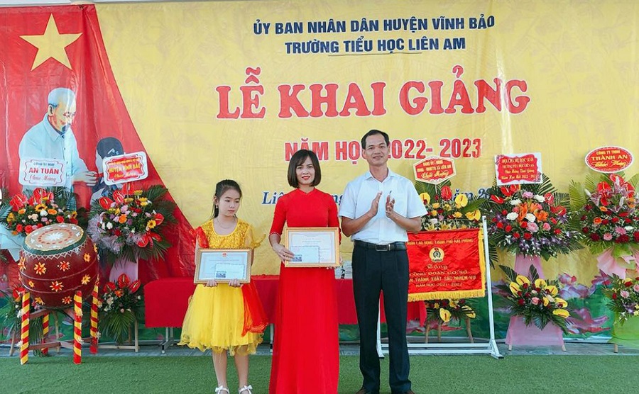 Đồng chí Vũ Xuân Quang, Phó chủ tịch Thường trực UBND huyện Vĩnh Bảo khen thưởng cô và trò Trường tiểu học Liên Am nhân dịp khai giảng năm học mới