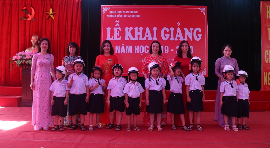 Các em học sinh Trường tiểu học An Dương tiếp nhận mũ bảo hiểm của Cty Hon đa Việt Nam trao tặng