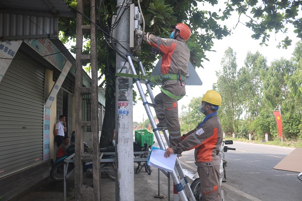 Mặc dù thời tiết nắng nóng nhưng công nhân Đội Kinh doanh dịch vụ Điện lực Tiên Lãng vẫn thực hiện công việc thay công tơ ghi số từ xa