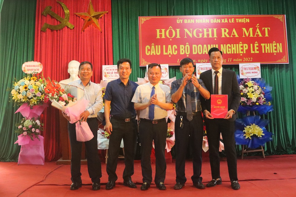 Đồng chí Trần Văn Hải, Huyện ủy viên, Bí thư Đảng ủy, Chủ tịch UBND xã Lê Thiện trao quyết định, tặng hoa ban chủ nhiệm câu lạc bộ.