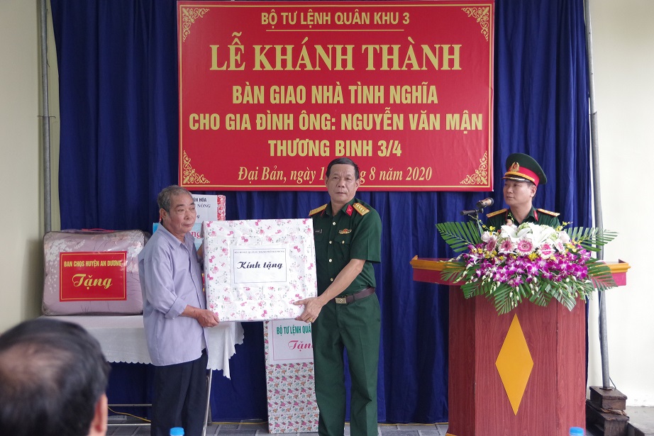 Đại tá Đào Văn Chi, Phó Chủ nhiệm Chính trị Bộ CHQS thành phố tặng quà cho thương binh Nguyễn Văn Mận.