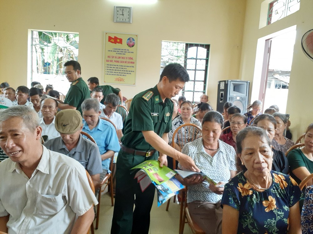 Cán bộ chiến sỹ Đồn Biên phòng Cát Hải phát tờ rơi cho nhân dân xã Hoàng Châu tham dự tại buổi tuyên truyền, phổ biến pháp luật.