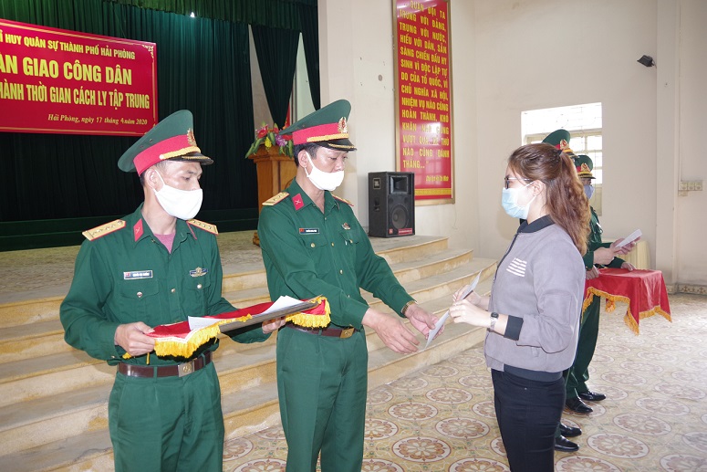 Đại diện Chỉ huy Trung đoàn 836 (Bộ CHQS thành phố Hải Phòng), trao giấy chứng nhận đã hoàn thành cách ly cho các công dân